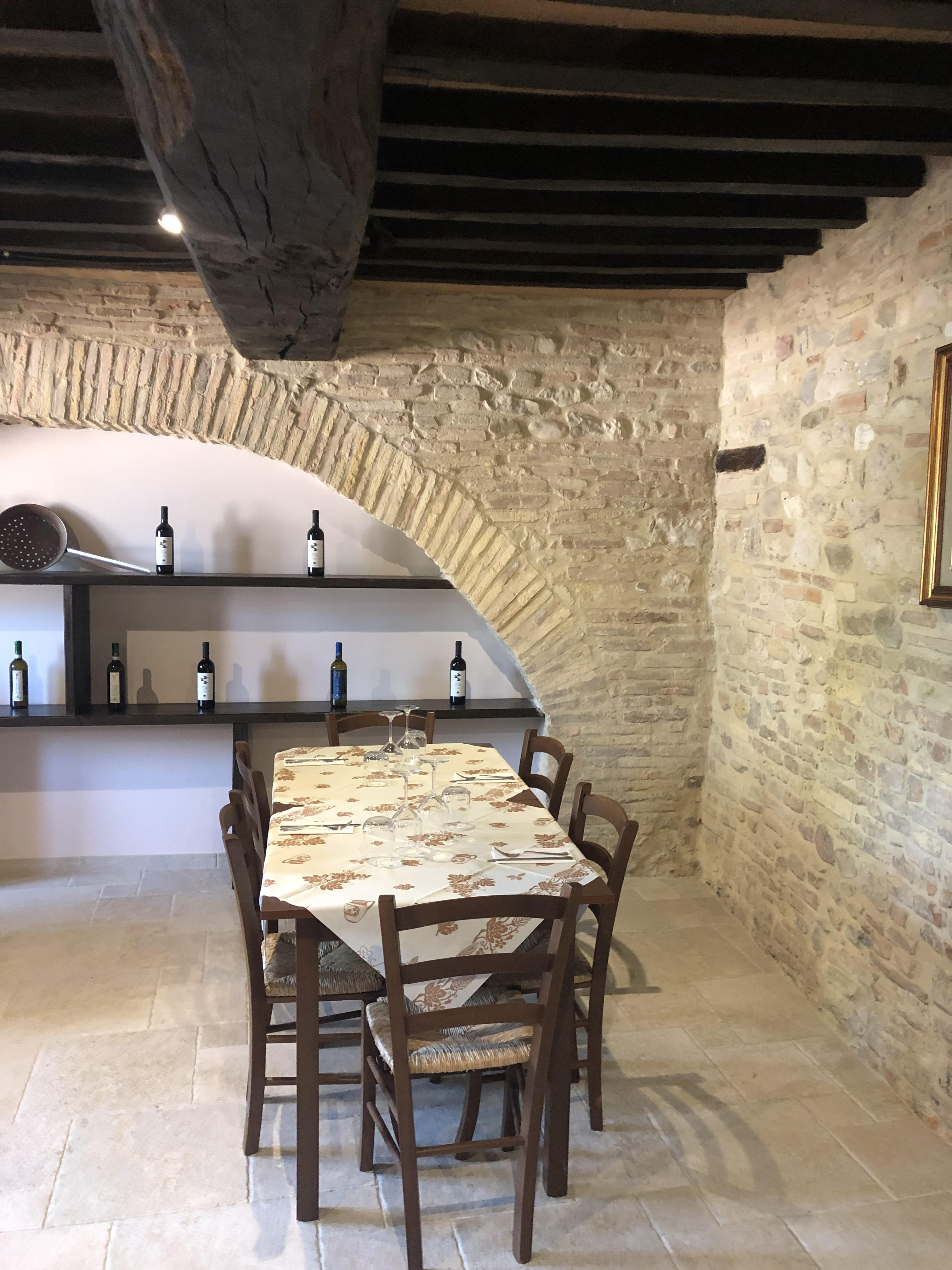 Sala interna del ristorante con volta in pietra e travi a vista
